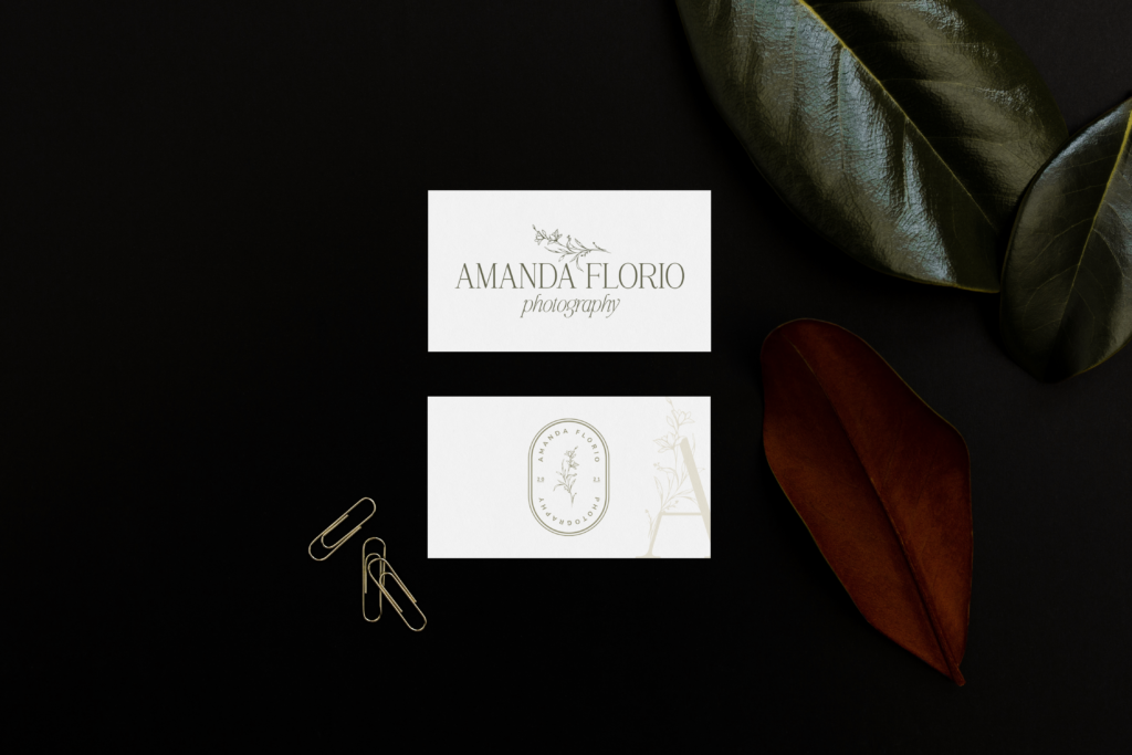 Wedding photographer logo mockup with 2 white business cards showing off her primary and brand mark on a dark leaf background.